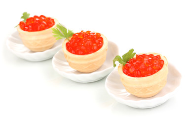 Red caviar in tartlets on little white saucers isolated on