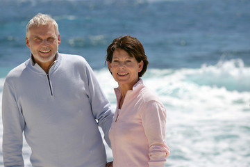Obraz premium Elderly couple enjoying stroll on the beach