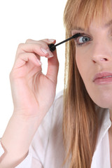 Fototapeta premium Woman applying mascara on her eyelashes
