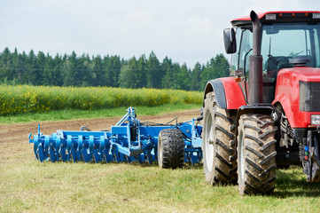 Ploughing tractor at field cultivation work