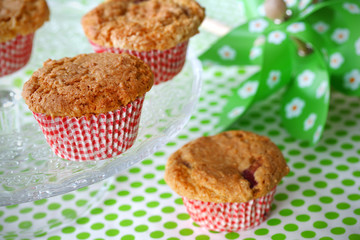 Fruit muffins on a cake stand and green tablecloth