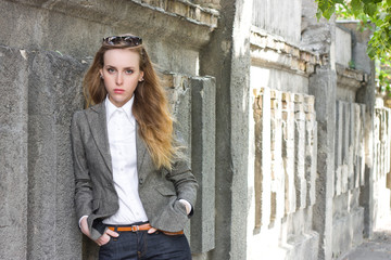 Sad woman stands near the wall