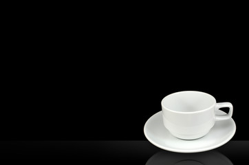 white cup and saucer isolated on black background
