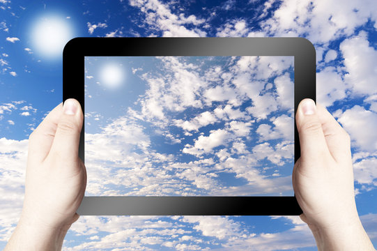 Hand Holding Tablet taking photo of beautiful sky