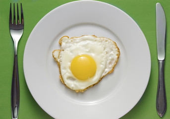 Fried egg on a plate with flatware