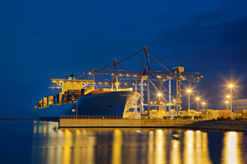 Large cargo ship on loading in the port at night.