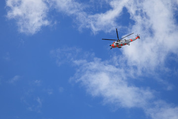 Fototapeta na wymiar Helicopter rescue in flight against blue sky background.