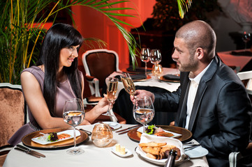 Beautiful couple with glasses of champagne at restaurant