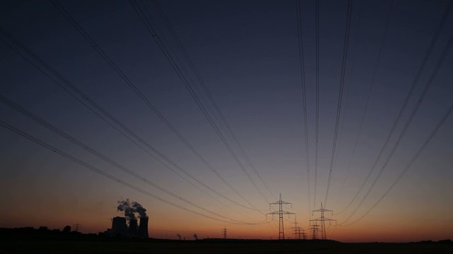 Power plant with power lines during sunset
