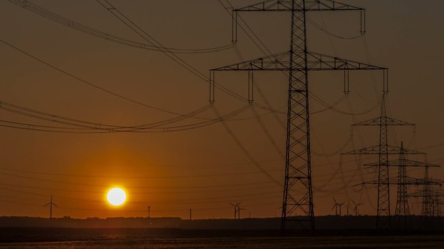 Sonnenuntergang Wind Turbinen mit &Uuml;berlandleitungen