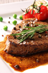 close-up of juicy beef steak covered with pepper  and salt