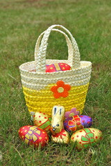 Basket of chocolate easter eggs and bunny on grass