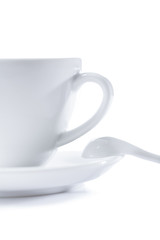 white cup on saucer with spoon isolated