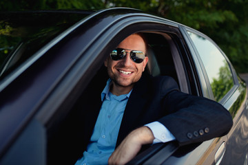 Businessman in car smiling