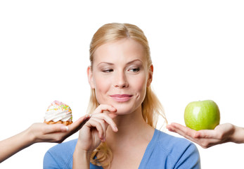 Beautiful woman makes a tough choice between cake and apple - 42272998