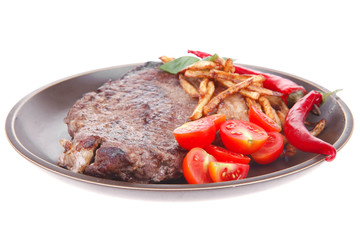 beef steak on dark plate with red hot chili pepper