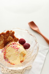 ice cream and crispy almond cooke with wooden spoon