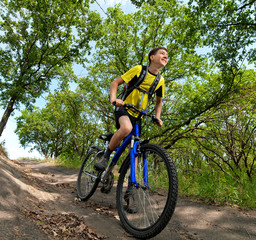 Fototapeta na wymiar A teenager on a bicycle traveling in the woods