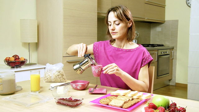 Attractive woman in pajamas having breakfast at home