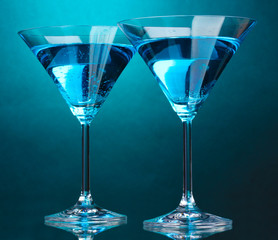 Blue cocktail in martini glasses on blue background