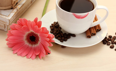 cup of coffee with lipstick mark and gerbera beans, cinnamon