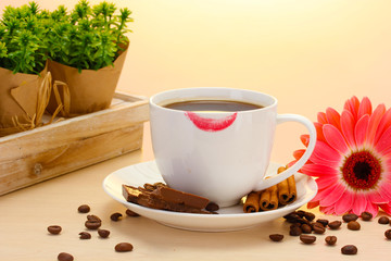 cup of coffee with lipstick mark and gerbera beans, cinnamon