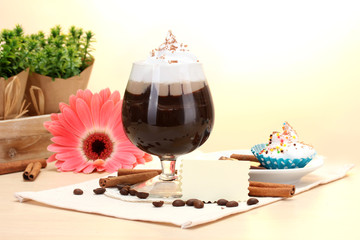 glass of coffee cocktail and gerbera flower on wooden table