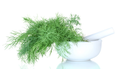 Dill in a mortar and pestle isolated on white