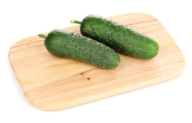 Fresh cucumbers on wooden board isolated on white