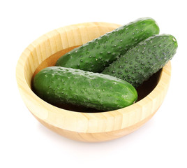 Fresh cucumbers in wooden bowl isolated on white