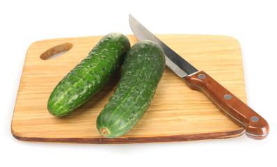 fresh cucumbers and knife on cutting board isolated on white