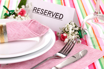 Table setting with reserved card in restaurant