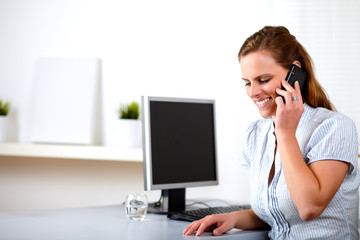 Friendly blonde secretary talking on cellphone
