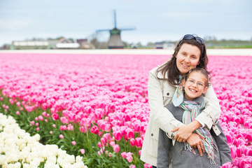 Girl with mother in the purple tulips field