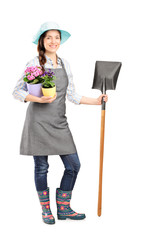 Full length portrait of a female worker holding a shovel