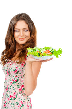 Girl holding a plate with salad, isolated on white