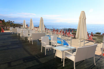 White tables and chairs in the hotel at dawn on the background o