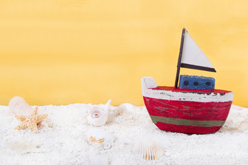 Rotes Segelboot aus Holz am Strand