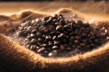 Selbstklebende Fototapeten Coffee beans with smoke in burlap sack © amenic181