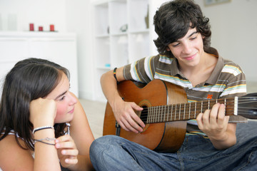 Young teenage couple with a guitar - Powered by Adobe