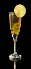 Yellow cocktail in glass with lime