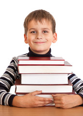 Schoolboy and a heap of books isolated on a white background