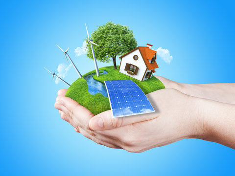 Hands holding clear green meadow alternative energy concept