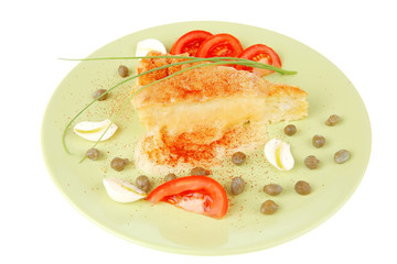 casserole piece over green plate served with chives and tomatoes
