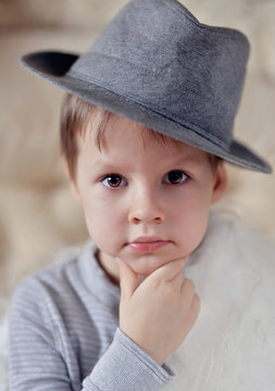 the emotional boy in a gray hat sits