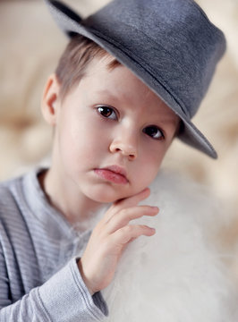 the emotional boy in a gray hat sits