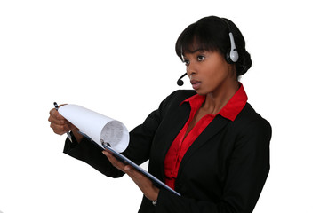 black businesswoman with headset holding clipboard