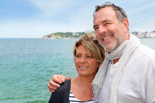 Portrait of senior couple standing by the sea