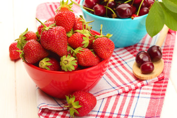 Ripe strawberries and cherry berries in bowls