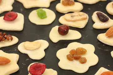 unbaked cookies with candied fruits and nuts in a pan close-up